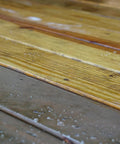 Image of wooden deck boards showing remnants of old stain and water spots after using One Gallon Ready To Roll Deck Stain Stripper.