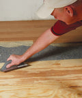 Pro Grade Flooring Underlayment Roll For Laminate Wood And Tile Sound Dampening Padding Compression Resistant Mat For Floating Glue Down Install Covers One Hundred Square Feet No Fuss Vibe Blocker Home Crew Staple being applied to subfloor.