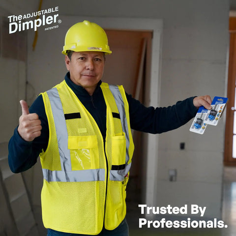 Construction worker holding Adjustable Drywall Bit And Screw Gun Attachment with magnetic bit holder in a building site.
