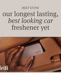 Drift gray stone car air freshener with metal clip being attached to a tan car interior