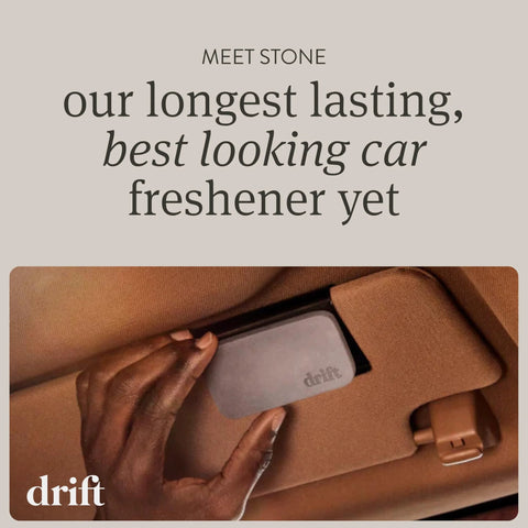 Drift gray stone car air freshener with metal clip being attached to a tan car interior