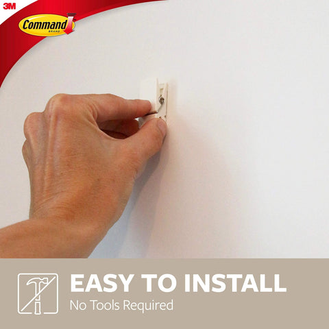 Installing a Quartz Plastic Spring Clip from 8 Pack for Dorm Décor, easy to mount without tools, shown on a white wall.