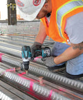 Worker using Rock Solid Eighteen Volt Cordless Hammer Driver Drill Kit Featuring Killer Torque Two Speed Gears on metal beams.