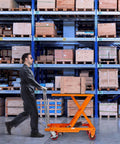 Heavy Duty Hydraulic Lift Table Cart With 500 Pound Capacity And 28.5 Inch Max Rise used to transport wooden crate in warehouse.