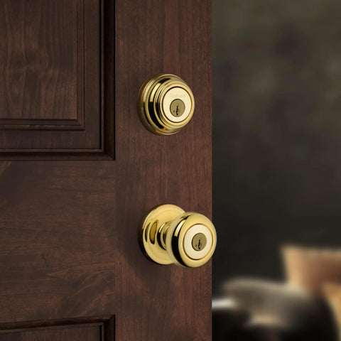 Keyed Front Door Knob And Deadbolt Set With SmartKey Rekey, Polished Brass Exterior Entry Kit installed on a wooden door