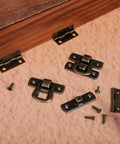 6 Piece Antique Bronze Latch And Hinges Set With Screws For Jewelry Boxes And Small Cabinets displayed on a wooden surface