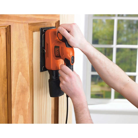 Person using Badass Compact Electric Orbital Sander With Rugged Ergonomic Design To smooth rough timber surface.