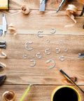 300 Piece Stainless Steel E Shaped Retaining Ring Kit With Storage Case displayed on a wooden workbench with tools.