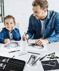 Father and son using All In One 42 Piece Drawing Set For Artists And Beginners with graphite pencils and accessories at a table.