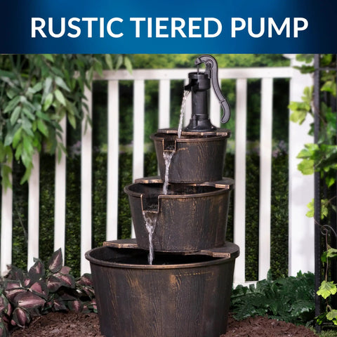 40 Inch Rustic Tiered Barrel Water Fountain For Outdoors with three stacked barrels next to a fence, in a garden setting.