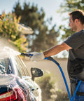Man using 50 Ft High Pressure Washer Hose 3600 PSI Flexible And Kink Resistant Replacement With One Quarter Inch Quick Connect on car