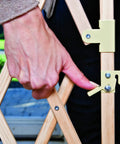 Close-up of hand operating the latch on Expansion Walk-Thru Baby Gate For Wide Open Spaces Fits 24 To 60 Inches Openings 32 Inches Tall Hardware Mount No-Fuss Install One Hand Latch Telescoping Safety Rail Keeps Tiny Fingers Safe Farmhouse Collection