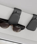 Premium Magnetic Sunglass Holder for Car Visor 2 Pack Soft Faux Leather Eyeglasses Clip holding sunglasses on car visor.