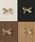 Brushed Gold Bow Dresser Knobs Set Of 8 on white, black, dark wood, and light wood surfaces, showing size and style variety.