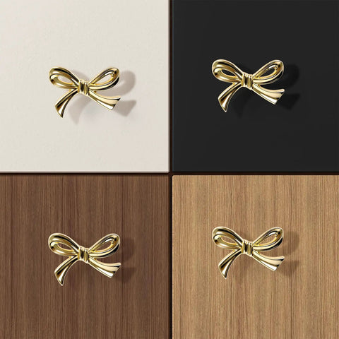 Brushed Gold Bow Dresser Knobs Set Of 8 on white, black, dark wood, and light wood surfaces, showing size and style variety.