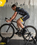 Cyclist using Magnetic Plus Indoor Bike Trainer with wheel on setup and quiet fluid resistance for realistic rides in home gym