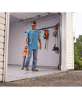 Person using Cordless Sweeper With Power Boost For Quick Yard Cleanup On Driveways Decks And Garages Includes Battery And Charger 20V Max Leaf Blower Style Tool For Debris Removal in garage