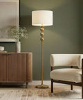 Riley 60 Inch Floor Lamp With Drum Shade In Gold Brass Finish For Living Room Or Bedroom Modern Standing Lamp With Boho Chic Mid Century Vibe And Elegant Corner Light For Office, shown in a living room setting.