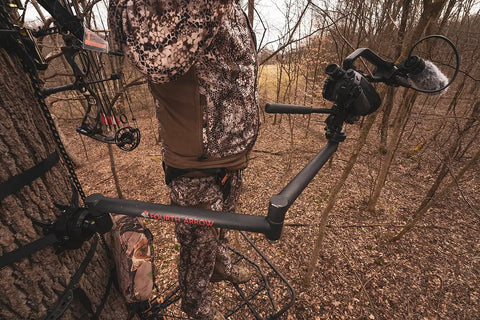 Hunter using Stiff Arm Tree Camera Arm Mount, Lightweight Aluminum With 360 Tool-Less Leveling for filming in a forest setup.