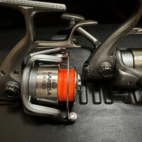 Two spinning reel handles with orange fishing line, showing Aluminum Alloy Fishing Reel Cap Replacement For Spinning Reels
