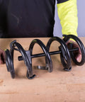 Heavy Duty Coil Spring Compressor With Detent Locks And Built In Safety Gauge for suspension service on wooden table