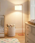 Rose Gold Montage Modern LED Floor Lamp for Living Rooms and Offices next to crib, softly lighting nursery corner with warm white light