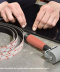 Hands applying Clear Low Profile Reclosable Fastener Roll Crafted From Tough Polyolefin Tape With Interlocking Mushroom Heads on a surface.