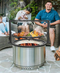 Santa Maria Style Rotisserie Rotating System for Solo Stove Yukon 27 Inch Smokeless Fire Pit in backyard grilling scene.