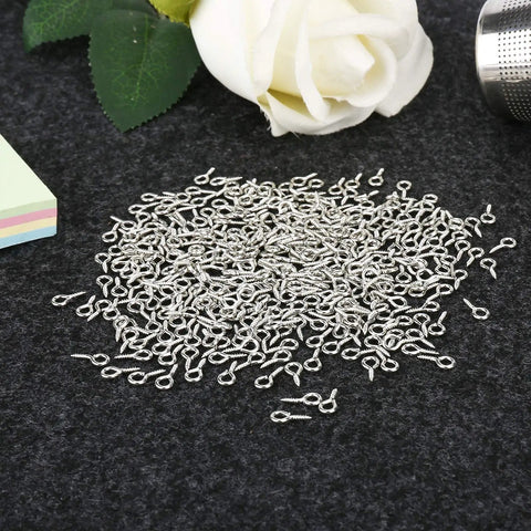 500 Pieces 4 By 8 Millimeter Small Screw Eye Pins For Jewelry Making And DIY Art Projects on dark fabric