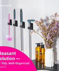 4 Pack Wall Mount Broom And Mop Holder Set With Ultra Anti Slip Grippers For Kitchen, Bathroom, Closet, Garden And Garage No Drilling Needed Space Saving Organizer Black installed, holding cleaning tools and surrounded by decor.