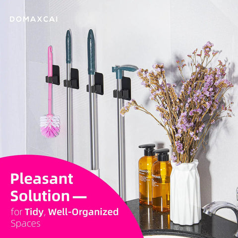 4 Pack Wall Mount Broom And Mop Holder Set With Ultra Anti Slip Grippers For Kitchen, Bathroom, Closet, Garden And Garage No Drilling Needed Space Saving Organizer Black installed, holding cleaning tools and surrounded by decor.