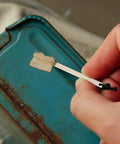Ultra Lightweight Titanium Keychain Pry Bar With Minimalist Slim Design Everyday Carry Essential For Your Keys Ready For Quick Fixes On The Go Durable Aircraft Grade Titanium Built For Real World Tasks in use removing tape from surface