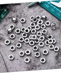 250Pcs Stainless Steel Hex Nuts And Machine Fasteners Pack spread out on a gray background, perfect for garage fixes.