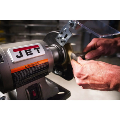 Shop Ready Six Inch Bench Grinder Powered By A Half Horsepower Motor Spinning 3450 RPM with hands working on metal piece.