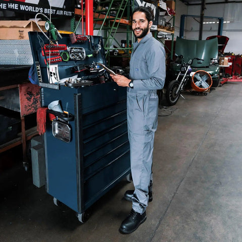 Men's Straight-Up Long Sleeve Twill Coverall Work Jumpsuit With Deep Cargo Pockets And Breathable Cotton Polyester Blend designed for mechanics, worn in a garage setting.