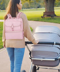Woman walking with a pink Premium Breast Pump Bag Featuring An Insulated Cooler Compartment For Wearable Pumping Backpack.
