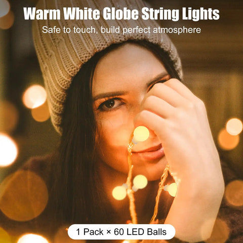 Person holding Battery Operated Globe Fairy String Lights With Remote, 21Ft Long, 60 Warm White LEDs, smiling
