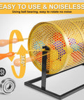 Gold-colored metal raffle drum with ball-bearing and wooden turning handle on black stand; holds 2500 tickets