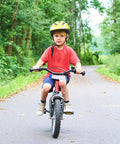Child riding a bike in park wearing red shirt and yellow helmet, showcasing Two Pack 14 Inch Bike Tubes Heavy Duty 14x2.10 To 14x2.50 AV32mm