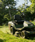 Green lawn mower in garden with 8 Ball Steering Wheel Assist Booster Grip Hand Control Spinner Suicide Knob For Agricultural Tractors Forklifts And Lawn Mowers Black Beefy Grip For Easy U Turn And Smooth Stop Heavy Duty Tractor Accessory.