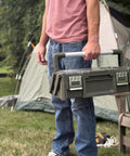 Person holding Olive Green Cantilever Tool Box Organizer with 18 removable bins and carry handle outdoors.