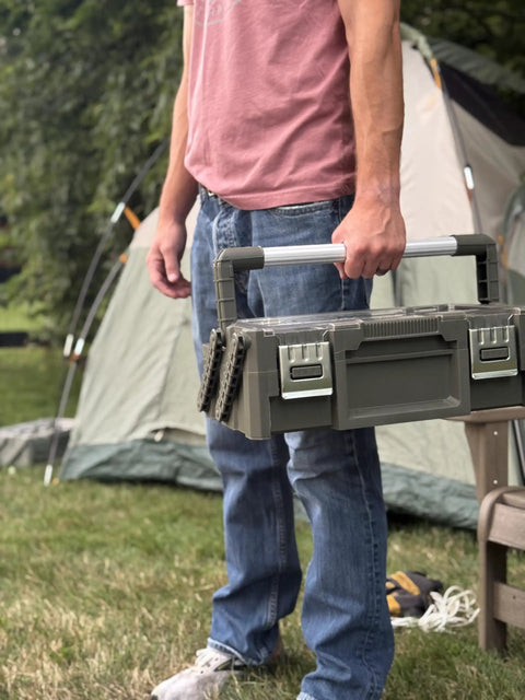 Person holding Olive Green Cantilever Tool Box Organizer with 18 removable bins and carry handle outdoors.