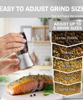 Hand using Stainless Steel Salt And Pepper Grinder Set Two Pack With Glass Jars, Adjustable Ceramic Burr Mills, on salmon with grind levels.