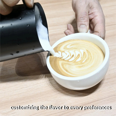 Barista pouring latte art into coffee cup on wooden table, showcasing espresso drink preparation