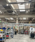 Heavy Duty 12ft HVLS Ceiling Fan With Brushless Motor And Built In VFD For Industrial And Commercial Use in a warehouse setting.