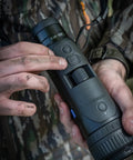 Close-up of a person adjusting a DTI 6/20 Thermal Imaging Camera With AMOLED Display and Night Ops Ready, showcasing controls.