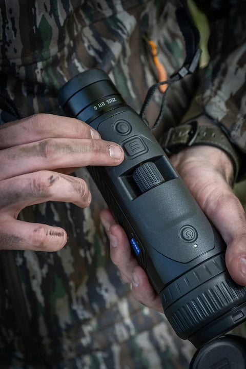 Close-up of a person adjusting a DTI 6/20 Thermal Imaging Camera With AMOLED Display and Night Ops Ready, showcasing controls.