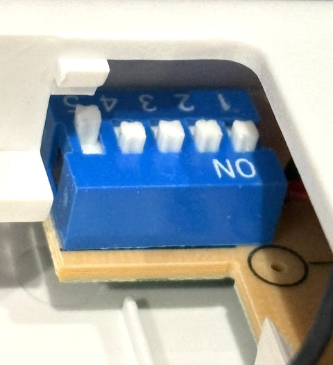 Close-up of dip switches on UC7848T V2 Fan Remote Transmitter Replacement With Wall Holder For Ceiling Fans, 5 Dip Switches, Includes Wall Mount, 9V Battery Not Included, Easy Install, Fits UC7848T V2 and Discontinued Versions.