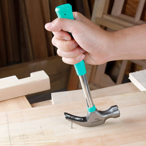 8 Oz Claw Hammer With Shock Reduction And Non Slip Grip Turquoise Handle For Home And Professional Use Durable Steel Construction Flat Head With Nail Puller And Prying Claw Comfort Grip That Reduces Vibration For Less Fatigue being used to remove a nail from wood