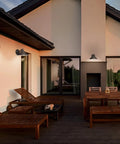 Go To Outdoor Wall Light In Bronze Aluminum Dark Sky Exterior Lantern illuminating a patio with lounge chairs and table